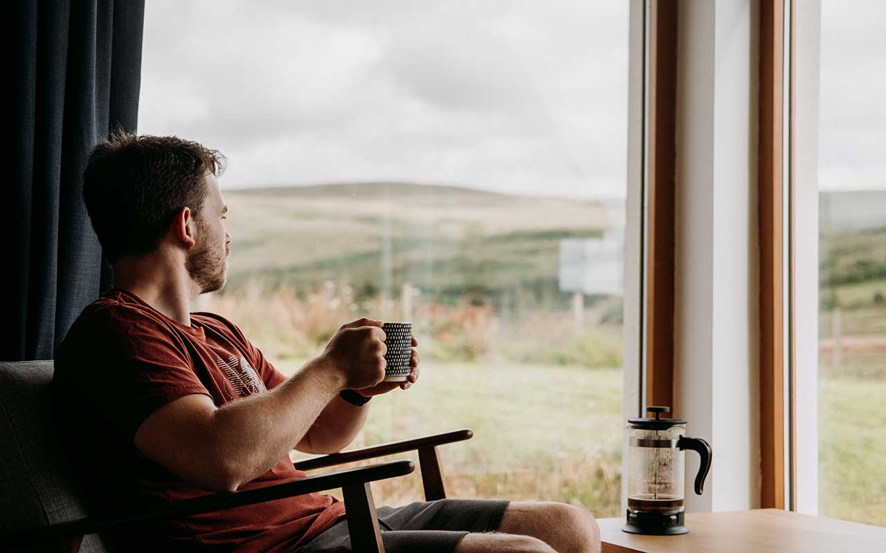 مردی در حال نوشیدن قهوه در بالکن